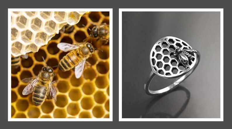 Op de afbeelding: Een zilveren ring met een honingraatontwerp en een kleine bij aan de zijkant. De ring ligt op een grijs oppervlak.