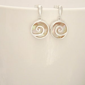 Peut inclure: Une paire de boucles d'oreilles en argent avec un motif en spirale de nacre blanche.