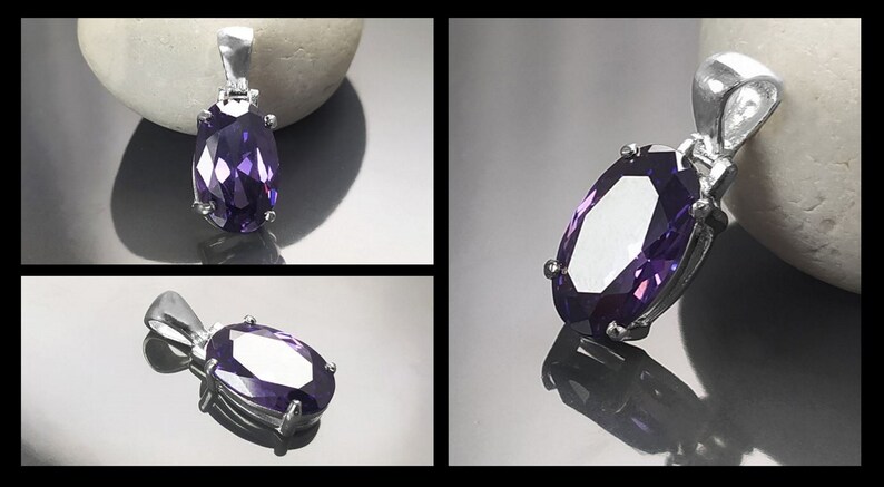 May include: A silver pendant with a large, faceted, oval-shaped purple gemstone.