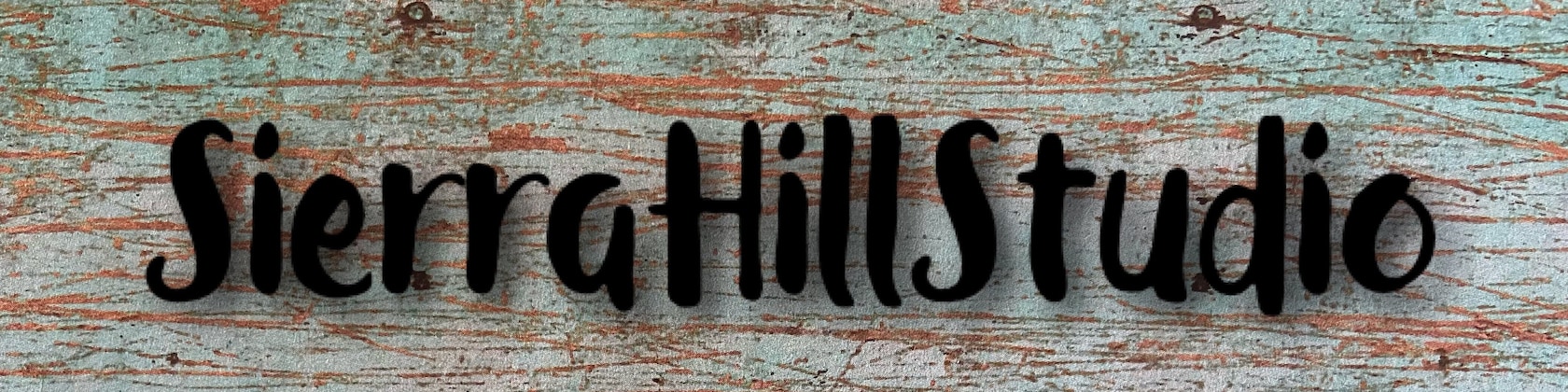 The Sierra Hill Studio sign on weathered turquoise wood
