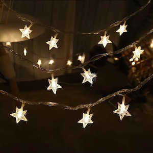 May include: String of white star-shaped fairy lights with warm white LED bulbs. The lights are strung on a clear wire and are perfect for adding a touch of magic to any room.