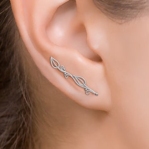 May include: Silver ear cuff with a delicate leaf design. The cuff is curved and has a small bead at the end.
