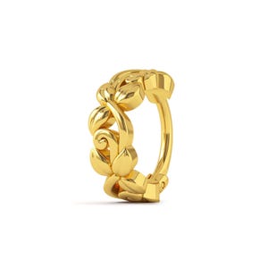 Puede incluir: Un aro para la nariz de oro con un diseño floral. El aro está hecho de una sola pieza de metal y tiene un acabado liso y pulido.