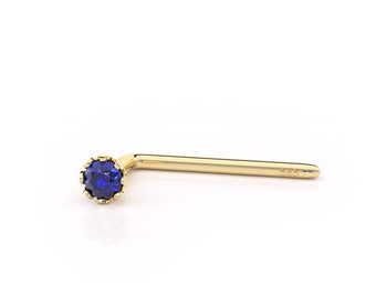 May include: A gold nose ring with a blue gemstone. The ring is marked "585" for 14 karat gold.