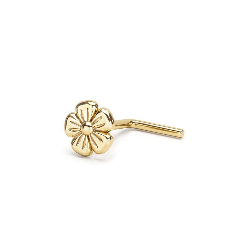 Pu&ograve; includere: Anello per il naso in oro a forma di fiore con un'asta curva. Il fiore ha un design dettagliato con un piccolo cerchio centrale.
