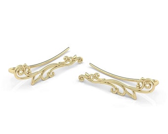 May include: A pair of gold ear cuffs with a delicate, intricate floral design. The cuffs are made of thin metal and have a curved shape that fits comfortably on the ear.