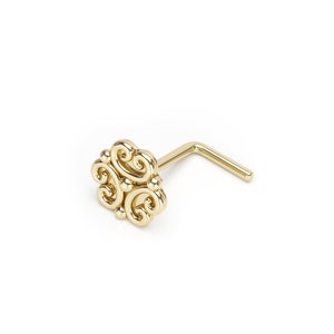 May include: Gold nose ring with a decorative swirl design.