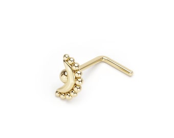 May include: Gold nose ring with a crescent moon design and a beaded edge.