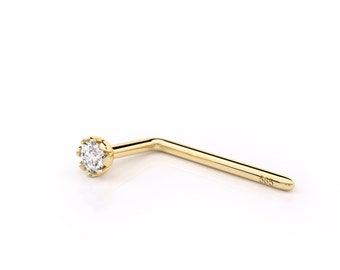 May include: A gold nose ring with a small, clear gemstone set in a prong setting. The ring is bent at a 90-degree angle.