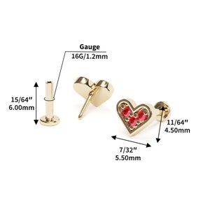 Puede incluir: Joyer&iacute;a corporal de oro en forma de coraz&oacute;n con piedras preciosas rojas. La joyer&iacute;a mide 11/64 pulgadas (4,50 mm) de ancho y 7/32 pulgadas (5,50 mm) de alto. El calibre es 16G/1,2 mm.