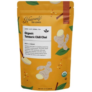 Può includere: Una busta gialla di tè alle erbe sfuso "Heavenly Tea Leaves". L'etichetta recita "Organic Turmeric Chili Chai" con illustrazioni di zenzero e testo che descrive il sapore speziato e robusto del tè. La confezione contiene 453 g di tè.