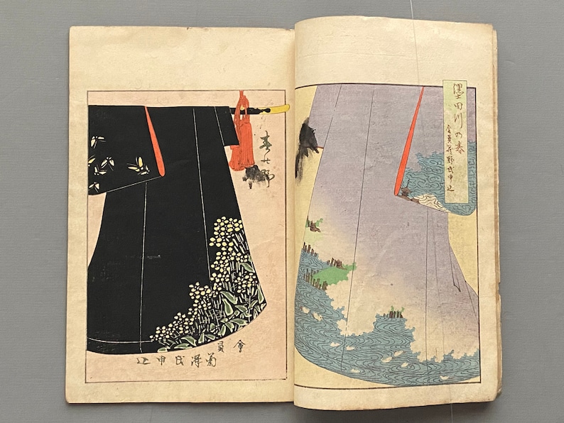 Op de afbeelding: Twee pagina's uit een Japans boek met een close-up van twee verschillende kimono-mouwen. De linkermouw is zwart met een bloemenpatroon en de rechtermouw is lichtblauw met een golfpatroon. De tekst op de pagina luidt: "[onbekende tekens]"