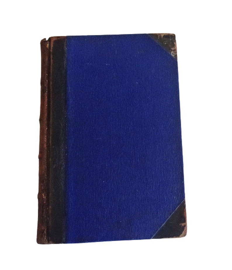 Puede incluir: Un libro antiguo de tapa dura con una cubierta azul oscuro y una encuadernaci&oacute;n y bordes de cuero marr&oacute;n.
