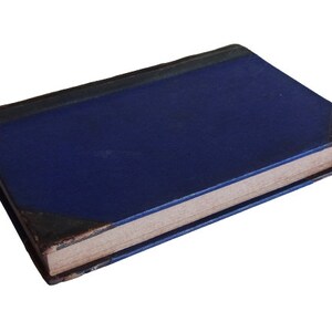 Puede incluir: Un libro de tapa dura azul con un aspecto desgastado y antiguo. El libro est&aacute; cerrado y acostado sobre un fondo blanco.