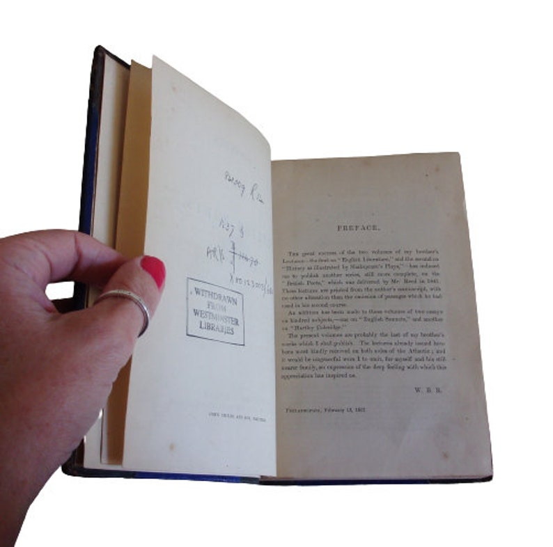 Puede incluir: Un libro abierto con una cubierta azul. El libro se titula "Prefacio" y contiene texto sobre el trabajo del autor. El libro est&aacute; estampado con "Retirado de las bibliotecas de Westminster".