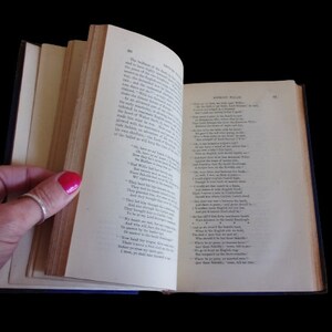 Puede incluir: Un libro abierto con p&aacute;ginas amarillentas y una cubierta azul. El texto en las p&aacute;ginas es un poema titulado "Barnabas McGuire".