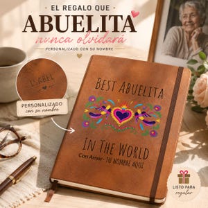 Puede incluir: Un cuaderno de piel sint&eacute;tica marr&oacute;n con cierre el&aacute;stico. La portada presenta el texto "BEST ABUELITA IN THE WORLD" y "Con Amor- TU NOMBRE AQU&Iacute;" con un gr&aacute;fico colorido de un coraz&oacute;n y p&aacute;jaros. Un recuadro circular muestra el nombre "ISABEL".