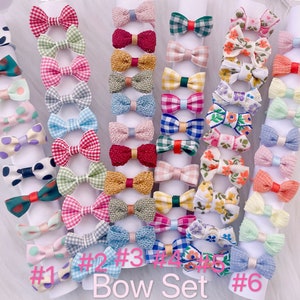 May include: A set of six different patterned hair bows. Each bow is made of fabric and has a different color and pattern. The bows are arranged in a row on a white background. The text "#1 #2 #3 #4 #5 #6 Bow Set" is printed below the bows.