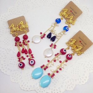 Longues boucles d’oreilles rouges blanches et bleues avec perles de verre, pierres dures et épingles Trinacria en laiton doré