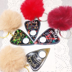 Schlüsselanhänger mit Kunstfell-Pom-Pom und Ouija-Zeiger aus Resin – Pastell-Gothic-Geldbörsendekor