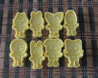 May include: Set of eight yellow plastic cookie cutters shaped like cartoon characters. The characters include a fox, a bunny, a cat, and a dog.