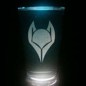 以下が含まれることがあります： スタイリッシュな狼の頭がフロスト加工された透明なガラス。ガラスは薄い青色の液体で満たされています