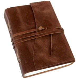 May include: A brown leather-bound journal with a flap closure and a leather strap with a knot. The journal has a rustic look and is perfect for writing or sketching.