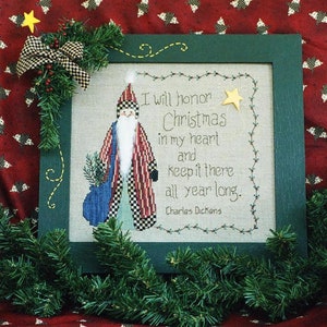 May include: A framed cross-stitch design featuring a cartoon Santa Claus holding a bag of gifts. The text reads "I will honor Christmas in my heart and keep it there all year long. Charles Dickens".