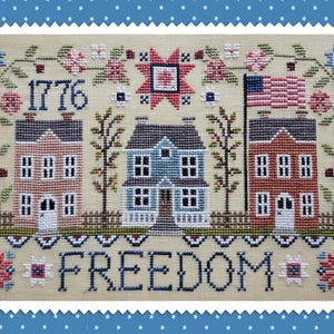 Pode incluir: Design de ponto cruz com três casas, uma bandeira americana e a palavra "FREEDOM". O ano "1776" é bordado acima das casas. O design incorpora motivos florais e de estrelas, com um esquema de cores patriótico em vermelho, branco e azul.
