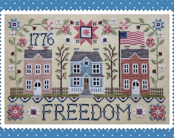 May include: Cross-stitch design depicting three houses, an American flag, and the word "FREEDOM." The year "1776" is stitched above the houses. The design incorporates floral and star motifs, with a patriotic colour scheme of red, white, and blue.