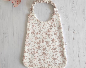 Bib in double gauze fabric with old pink foliage pattern Oekotex, elasticated neck strap.