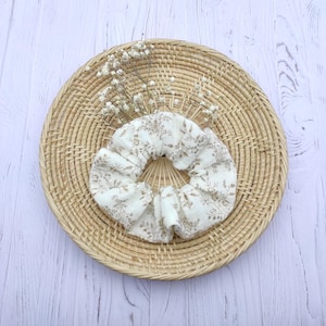 children&#39;s hair scrunchie with small beige flower pattern.