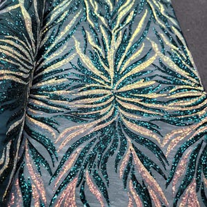 May include: Teal and gold iridescent sequins on a mesh fabric with a flame-like pattern.