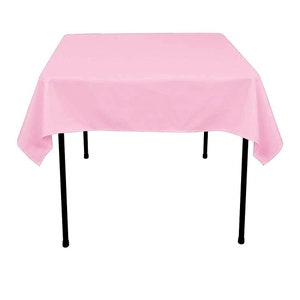 May include: A pink tablecloth with a square shape and black metal legs. The tablecloth is made of a smooth, wrinkle-free fabric.