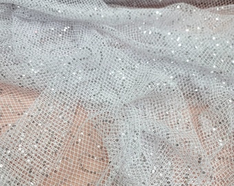 May include: White mesh fabric with silver sequins. The fabric is sheer and has a delicate texture.