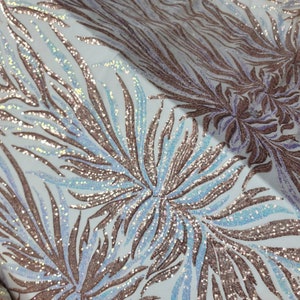 May include: White fabric with a rose gold and iridescent blue sequin pattern of stylized leaves.
