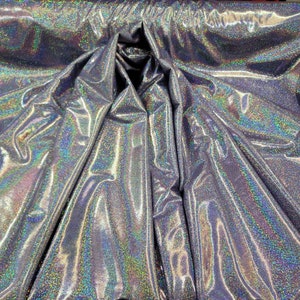 May include: Silver iridescent fabric with a glittery finish. The fabric is folded and draped, showing its texture and sheen.