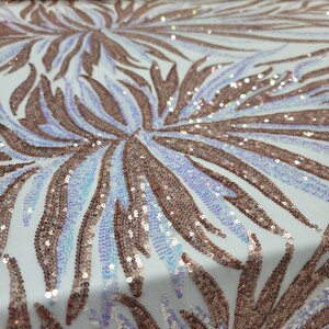 May include: White mesh fabric with a rose gold iridescent sequin pattern. The sequins are arranged in a swirling leaf design.
