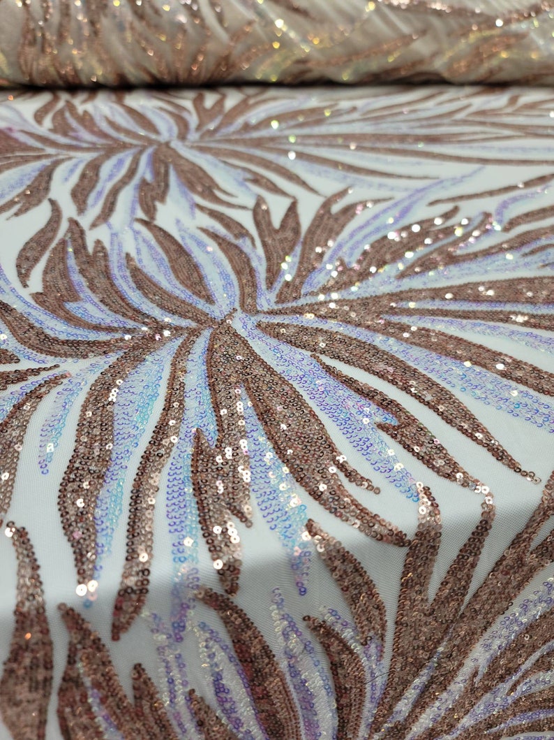 May include: White mesh fabric with a rose gold iridescent sequin pattern. The sequins are arranged in a swirling leaf design.