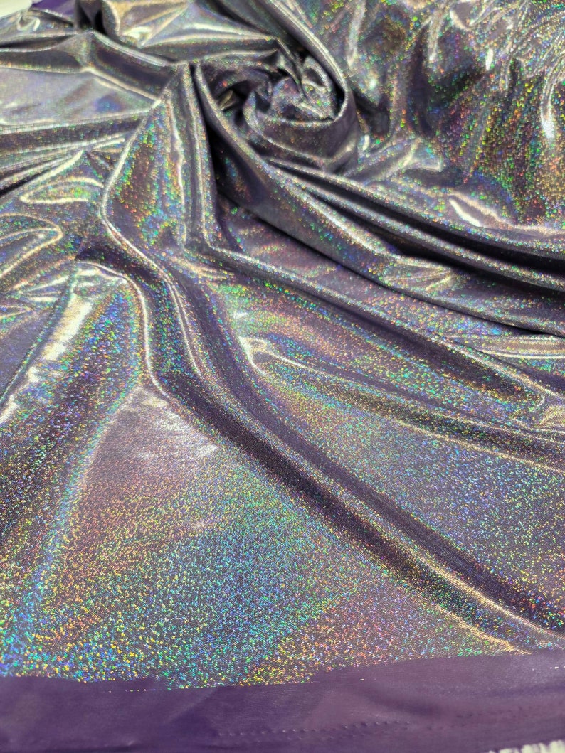 May include: A silver iridescent fabric with a purple edge. The fabric has a subtle sparkle and a smooth texture.