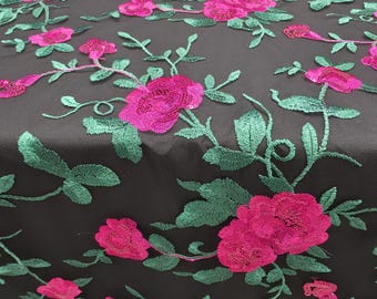 May include: A black mesh fabric featuring an intricate floral embroidery pattern. The design consists of vibrant hot pink roses and detailed green leaves and stems stitched across the surface, creating a textured and layered appearance.