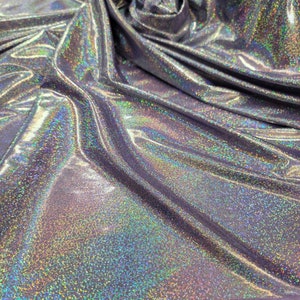 May include: A close-up of iridescent silver fabric with a purple border. The fabric has a subtle sparkle and a smooth texture.