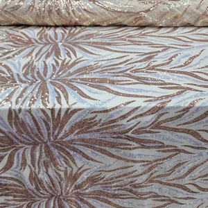 May include: White fabric with a rose gold and iridescent sequin pattern of abstract flames. The fabric has a subtle shimmer.