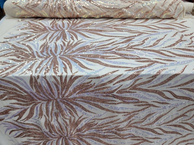 May include: White fabric with a rose gold and iridescent sequin pattern of abstract flames. The fabric has a subtle shimmer.