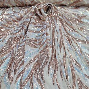 May include: White mesh fabric with a rose gold sequin pattern. The sequins are arranged in a wavy, flowing design.
