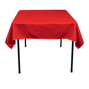 May include: A red square tablecloth draped over a black metal table.