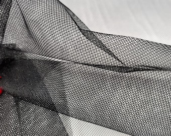 Peut inclure: Tulle noir avec un motif en maille fine. Le tissu est doux et transparent, et il a un drapé délicat.