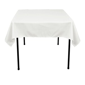 May include: White rectangular tablecloth with black metal legs. The tablecloth is draped over the table and hangs down on all sides.