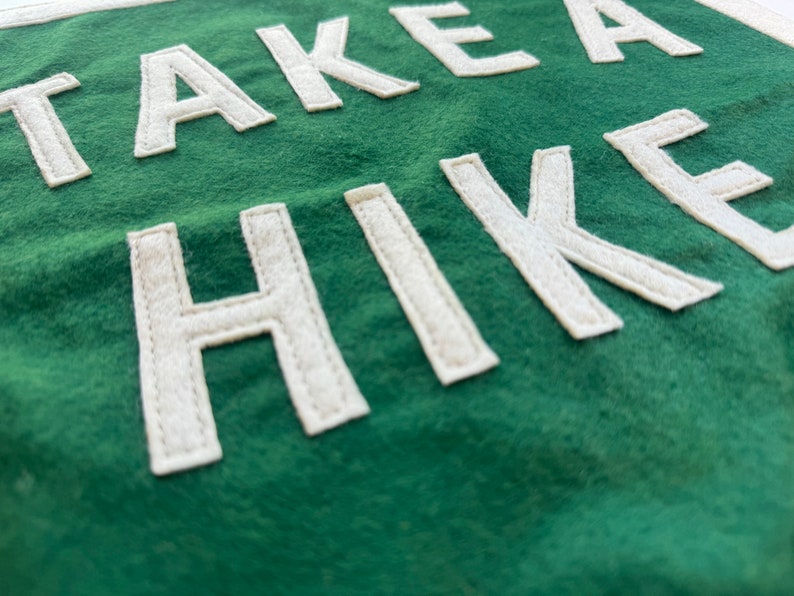 May include: A green fabric banner with white felt lettering that reads "TAKE A HIKE".