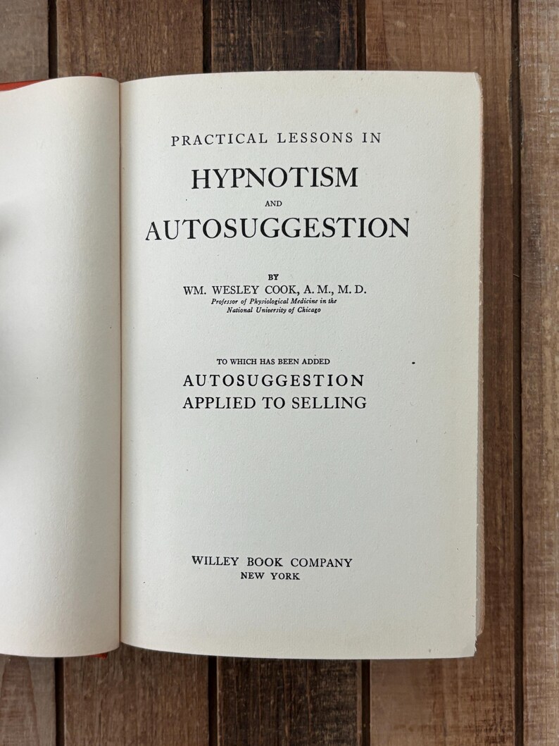 Peut inclure: Un livre ouvert intitul&eacute; "Practical Lessons in Hypnotism and Autosuggestion" par Wm. Wesley Cook. La couverture du livre est blanche avec du texte noir. Le texte "Autosuggestion Applied to Selling" est &eacute;galement visible. Publi&eacute; par Willey Book Company, New York.